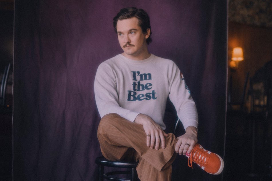 photo of Chris Farren sitting with his legs crossed